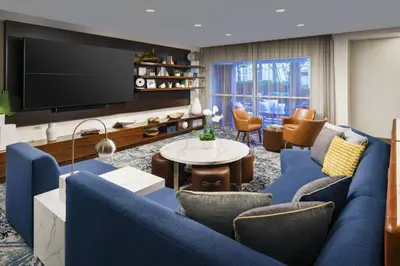 a living room with a blue couch and a tv at Courtyard by Marriott Orlando Downtown in Orlando