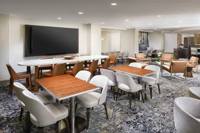 a room with tables and chairs and a flat screen tv at Courtyard by Marriott Orlando Downtown in Orlando