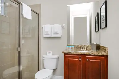 a bathroom with a toilet and a shower and a sink at Spectacular Home Near Disney With Private Pool, Movie Theater And Pool Table With Waterpark & Resort Access - 332Sf in Kissimmee