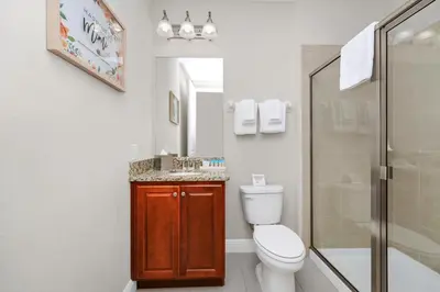 a bathroom with a toilet and a sink and a shower at Spectacular Home Near Disney With Private Pool, Movie Theater And Pool Table With Waterpark & Resort Access - 332Sf in Kissimmee