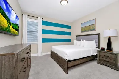 a bedroom with a bed and a tv at Spectacular Home Near Disney With Private Pool, Movie Theater And Pool Table With Waterpark & Resort Access - 332Sf in Kissimmee