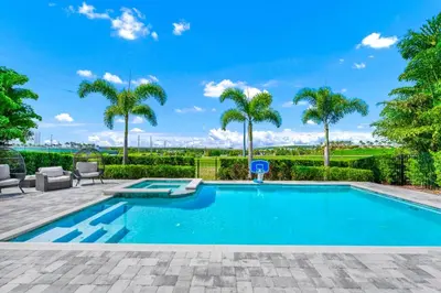 a swimming pool with palm trees in the background at Spectacular Home Near Disney With Private Pool, Movie Theater And Pool Table With Waterpark & Resort Access - 332Sf in Kissimmee