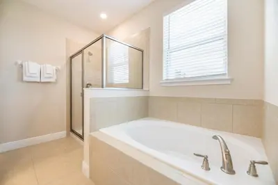 a bathroom with a large tub and a window at Spectacular Home Near Disney With Private Pool, Movie Theater And Pool Table With Waterpark & Resort Access - 332Sf in Kissimmee