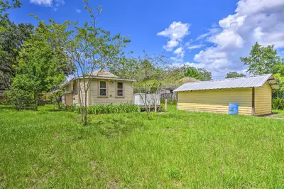 a small yellow house in a field of grass at 16 Mi to Disney Cottage with Deck in Winter Garden in Orlando