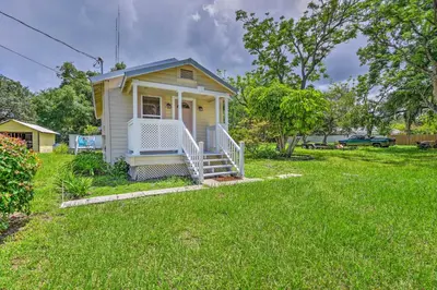 a small yellow house in a field of grass at 16 Mi to Disney Cottage with Deck in Winter Garden in Orlando