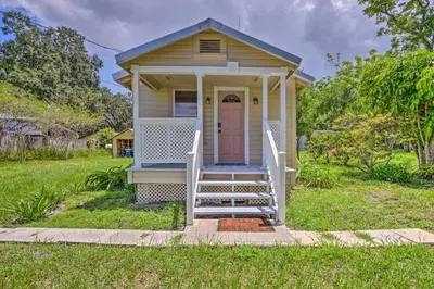 a small house with a pink door on a yard at 16 Mi to Disney Cottage with Deck in Winter Garden in Orlando