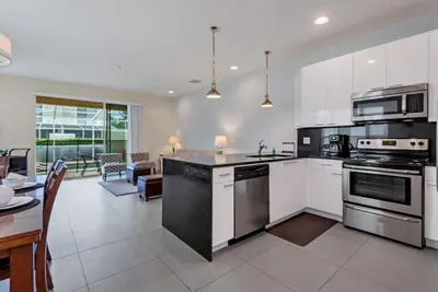 a kitchen with stainless steel appliances and a living room at Serenity 3 Bed Townhome townhouse in Orlando
