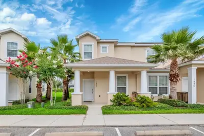 a house with palm trees in front of it at Serenity 3 Bed Townhome townhouse in Orlando