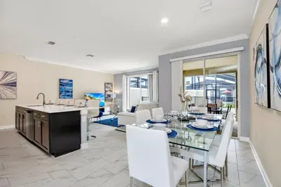 a kitchen and living room with a glass table and chairs at Brand New Storey Lake Resort With Water Slides townhouse in Kissimmee