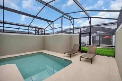 a swimming pool in a building with two chairs at Brand New Storey Lake Resort With Water Slides townhouse in Kissimmee