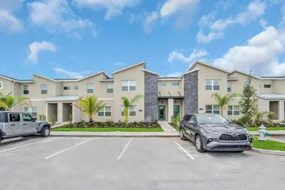 a car parked in a parking lot in front of a building at Brand New Storey Lake Resort With Water Slides townhouse in Kissimmee