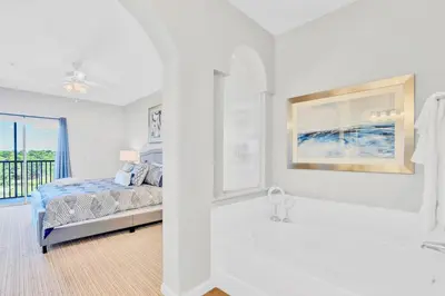 a white bedroom with a bed and a bath tub at Modern 3BR - Near Disney - Pool in Orlando