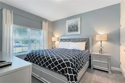 a bedroom with a bed with a black and white comforter at Storey Lake 4 Bedroom Townhome townhouse in Kissimmee