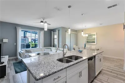 a kitchen with a sink and a living room at Storey Lake 4 Bedroom Townhome townhouse in Kissimmee