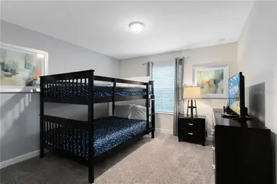 a bedroom with two bunk beds and a desk at Storey Lake 4 Bedroom Townhome townhouse in Kissimmee