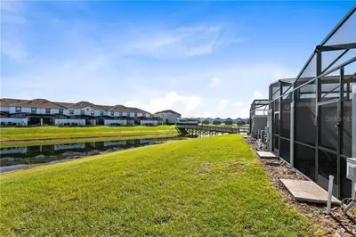 a grassy field next to a building with houses in the background at Storey Lake 4 Bedroom Townhome townhouse in Kissimmee