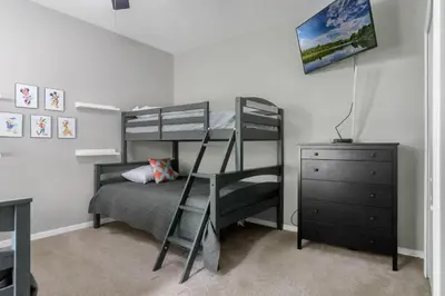 a bedroom with two bunk beds and a dresser at Cozy Apartment Only Miles From Disney Community Pool And Jacuzzii in Kissimmee