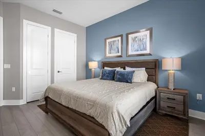 a bedroom with a large bed with blue walls at Magical Vacation Home 3 min from Disney in Orlando