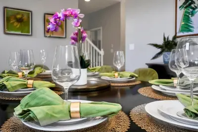 a dining room table with plates and wine glasses at Appealing, Large 5BD Home Close to Themed-Parks #5PP961 in Kissimmee