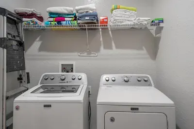 a kitchen with a stove and a drying rack with towels at Spacious 6BR Villa Pool Parking Near Disney World in Orlando
