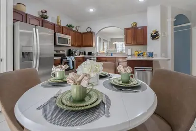 a kitchen with a white table and chairs at Spacious 6BR Villa Pool Parking Near Disney World in Orlando
