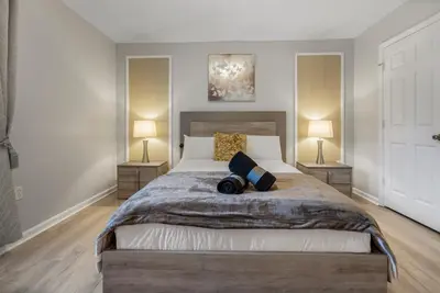 a bedroom with a large bed with two lamps at Spacious 6BR Villa Pool Parking Near Disney World in Orlando