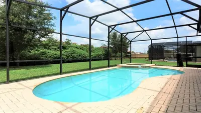 a swimming pool in a pavilion with a large blue pool at Spacious 6BR Villa with Pool SPA 3 Miles to Disney in Orlando