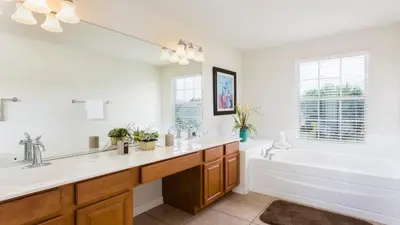 a white bathroom with a tub and a sink and a tub and a bath tub at Spacious 6BR Villa with Pool SPA 3 Miles to Disney in Orlando