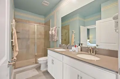 a bathroom with two sinks and a shower at Luxury Villa near Disney 8 Bedroom Private Pool & Playground1 in Kissimmee