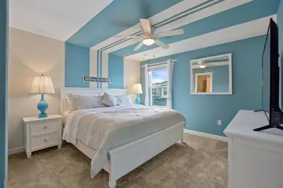 a blue bedroom with a bed and a ceiling fan at Luxury Villa near Disney 8 Bedroom Private Pool & Playground1 in Kissimmee