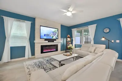 a living room with a white couch and a tv at Luxury Villa near Disney 8 Bedroom Private Pool & Playground1 in Kissimmee