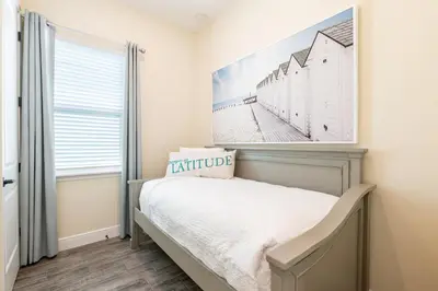 a bedroom with a bed with a picture on the wall at Sunrise Cottage Near Disney With Margaritaville Resort & Island H20 Waterpark Access - 2966Sr in Orlando