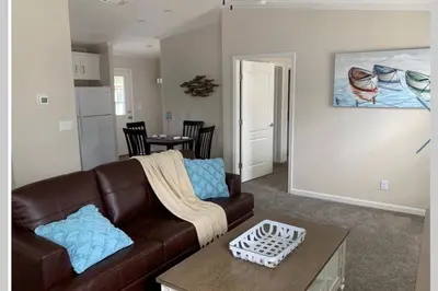 a living room with a brown couch and a table at Resort Cottage near parks at Great Price! in Kissimmee