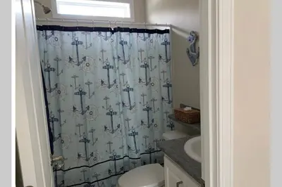 a bathroom with a shower curtain and a toilet at Resort Cottage near parks at Great Price! in Kissimmee