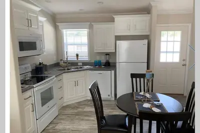 a kitchen with a table and a white refrigerator at Resort Cottage near parks at Great Price! in Kissimmee