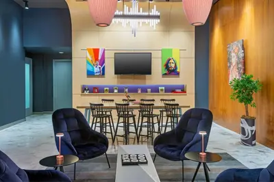a lobby with chairs and a bar with a tv at Aloft Orlando Downtown in Orlando