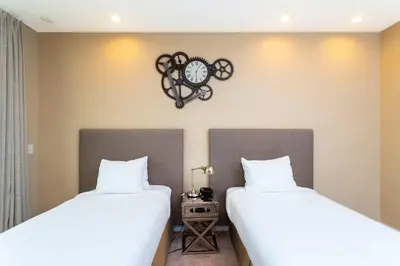 a bedroom with two beds and a clock on the wall at Gorgeous 4Bd Close to Disney @ Magic Village 7581 in Orlando