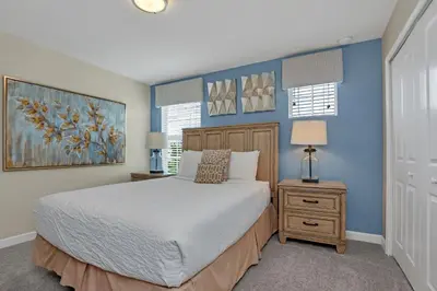 a bedroom with a bed and a blue wall at LAKEVIEW Home w Private Pool FREE Water Park in Kissimmee