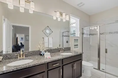 a bathroom with two sinks and a shower at LAKEVIEW Home w Private Pool FREE Water Park in Kissimmee