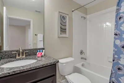 a bathroom with a sink and a toilet and a mirror at LAKEVIEW Home w Private Pool FREE Water Park in Kissimmee
