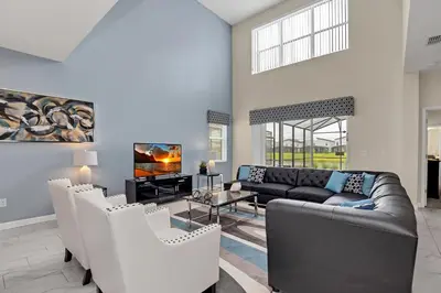 a living room with a couch and a tv at LAKEVIEW Home w Private Pool FREE Water Park in Kissimmee