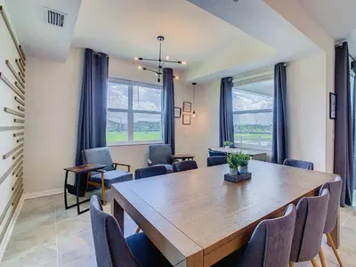 a dining room with a wooden table and chairs at Cute Lakeview 2BR Condo with 2 Clubhouses in Kissimmee