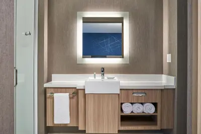 a bathroom with a sink and a mirror and towels at SpringHill Suites by Marriott Winter Park in Orlando