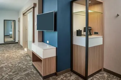 a corridor of a hotel room with a tv on a wall at SpringHill Suites by Marriott Winter Park in Orlando