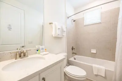 a bathroom with a sink and a toilet and a tub at Sky Blue Cottage With Private Pool Near Disney With Margaritaville Resort & Island H2O Access - 8045Kd in Orlando