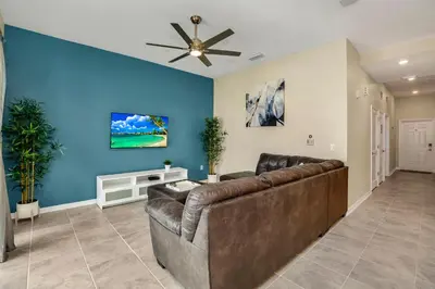 a living room with a couch and a ceiling fan at Cozy Condo Near Disney wPool View FREE WaterPark in Kissimmee