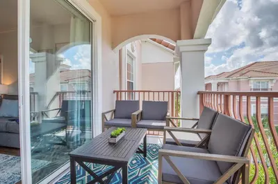 a patio with two chairs and a table on a balcony at Top floor condo with view of lake, pool and fireworks! Next to Convention Center! in Orlando