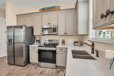 a kitchen with white cabinets and a stainless steel refrigerator at 8044 Sandy Toes Way in Orlando