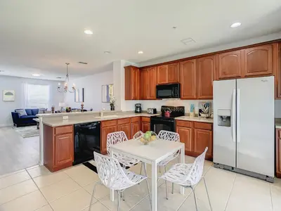 a kitchen with a white table and a white refrigerator at Stylish Vista Cay Townhome Near Conv. Ctr I-Dr. in Orlando