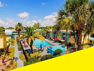a view of a resort with a pool and palm trees at Bposhtels Orlando Florida Mall in Orlando